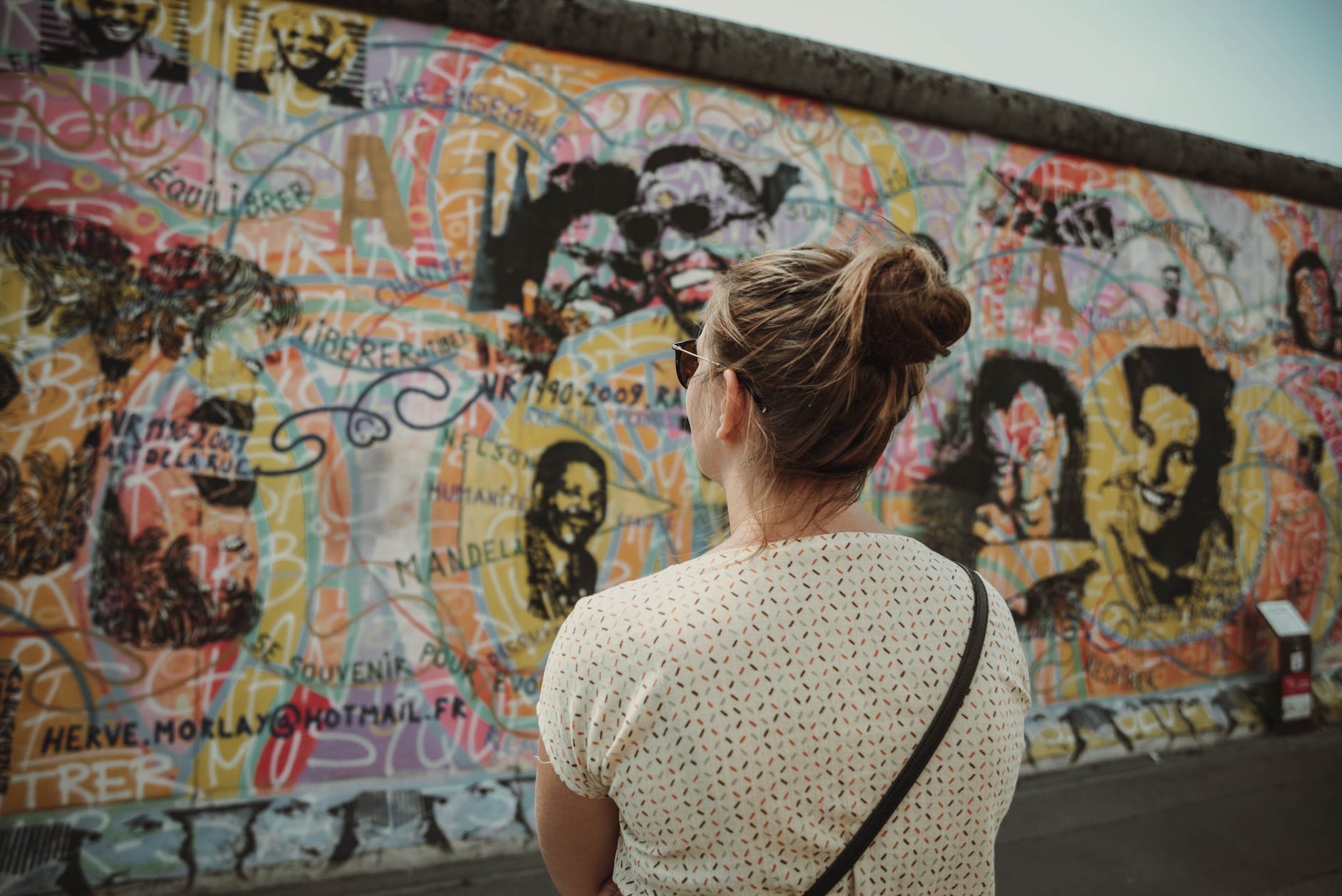 a woman looking at the berlin wall